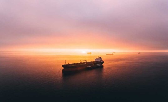 ship sailing on the ocean during sunset