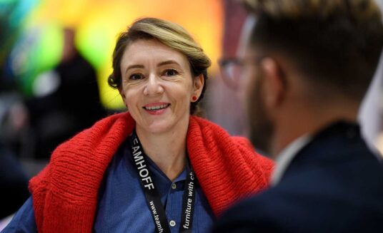 a female attendee at cruise ship interiors design expo europe 2021 smiling whilst looking at the camera