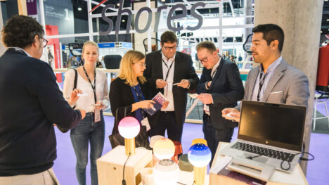 a cruise ship interiors design expo europe exhibitor exchanging business cards with a visitor at their stand at csie 2019